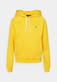 Gul huvtröja med känguruficka, vita dragsko, och en liten blå logotyp på bröstet. Tyget har en mjuk, texturerad yta.