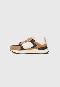 Sneakers con tomaia in suede beige e marrone, accenti sintetici neri, linguetta e tallone in crema, suola testurizzata e design a contrasto.