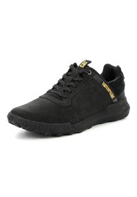 Scarpa sportiva nera realizzata in suede e tessuto. Presenta una chiusura con lacci, suola in gomma testurizzata e dettagli del logo in giallo e nero.
