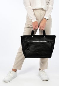 Black leather tote bag with a textured finish, featuring a top zipper, front pocket with zipper, and dual handles for easy carrying.