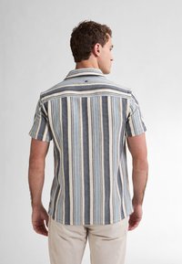 Korte mouwen overhemd met verticale blauwe, beige en marine gestreepte ontwerpen; gestructureerde stof; puntige kraag; label op de achterkant van de schouderpas; casual fit.