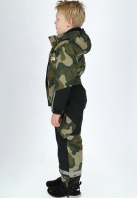 Camouflage jack met een capuchon, elastische manchetten en een voorzak; gecombineerd met zwarte broek met camouflageaccenten en reflecterende strepen.