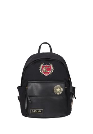 Zaino nero con tasca frontale, chiusure a cerniera, toppa con stemma rosso e oro e due patch decorativi tra cui una stella e un'etichetta codice.