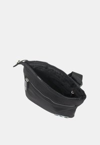 Borsetta nera con zip realizzata in un tessuto liscio dal design elegante. L'interno presenta una fodera con marchio e una tracolla attaccata sul lato.