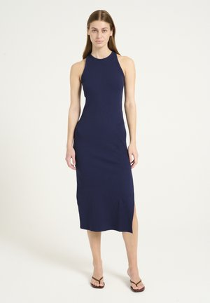 Marineblauwe geribbelde midi-jurk met een hoge halslijn, een zijspleet en een nauwsluitende silhouet. Gemaakt van een rekbare stof. Bevat geen extra patronen of accenten.