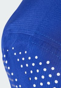 Blue athletic top with a textured fabric featuring multiple white perforations. Stitching details visible along the seams. Smooth, fitted design.