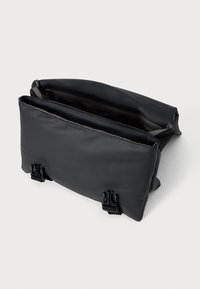 Svart rektangulær veske med en glatt, matt overflate. Har to rom og spenner for lukking. Innvendig fôr med stoff.