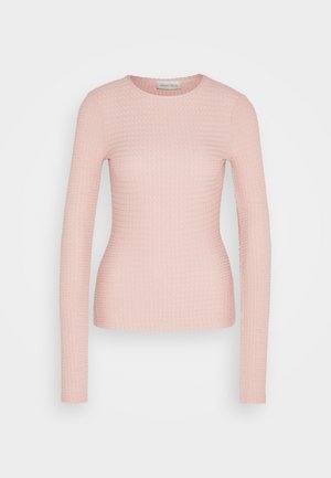 Top de manga larga color rosa claro con un diseño texturizado acanalado. Presenta un escote redondo y una silueta ajustada. La tela parece suave y elástica.