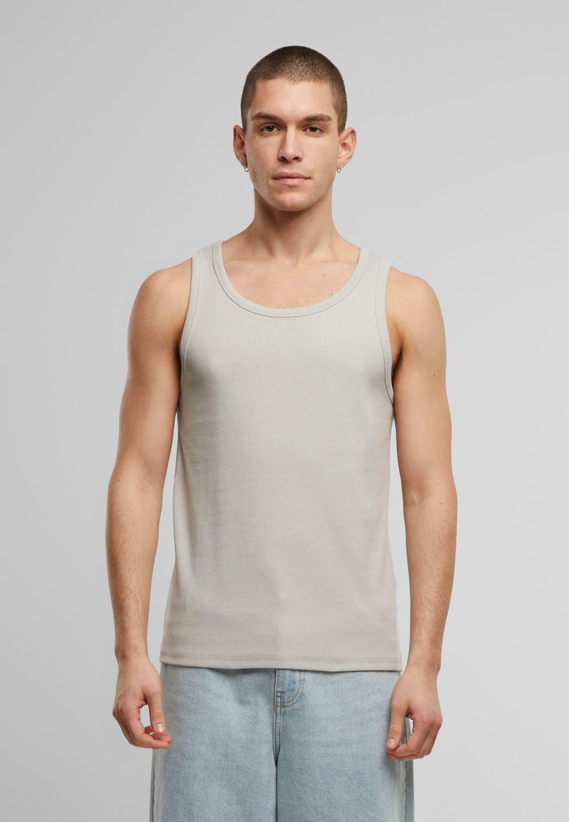 Lys grå ribbet tanktop med rund halsudskæring, lavet af blødt stof, kombineret med lyseblå denimshorts. Enkel og funktionel design.