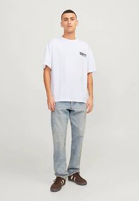 Balti medvilninė trumpomis rankovėmis marškinėliai, kairėje pusėje su juodu tekstu. Derinami su šviesiai mėlynomis džinsais ir rudeninėmis ruda sportbačiais.