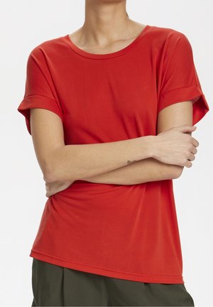 T-shirt rosso a maniche corte con scollatura rotonda, in tessuto morbido e maniche arrotolate, con vestibilità casual e un orlo leggermente curvo.