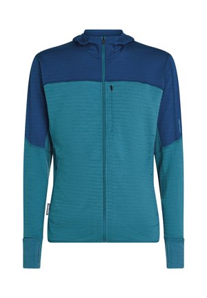 Heren zip-up jack met lange mouwen en duimgaten in teal en marineblauw, met een borstzak met rits en een hoge kraag.