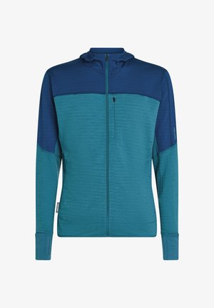Herren Langarm-Zip-Jacke in Teal und Marineblau mit Daumenlöchern, ausgestattet mit einer Reißverschlusstasche in der Brust und hohem Kragen.