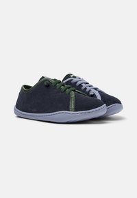 Chaussures en daim bleu marine avec des lacets verts et gris contrastants, dotées d'une semelle en caoutchouc flexible et de détails cousus.