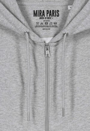 Sweat à capuche gris zippé en 100 % coton, avec une texture douce, une fermeture éclair à l'avant, un cordon de serrage et des étiquettes imprimées à l'intérieur.