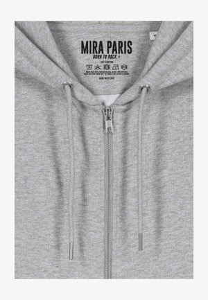 Sweat à capuche gris zippé en 100 % coton, avec une texture douce, une fermeture éclair à l'avant, un cordon de serrage et des étiquettes imprimées à l'intérieur.