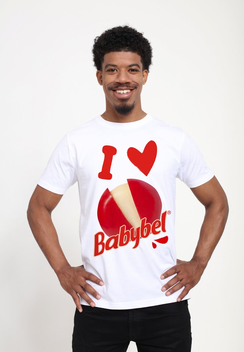 Bílý tričko s krátkým rukávem, které má velké červené "I ♥" a červenobílé logo sýra Babybel. Grafika je výrazná a barevná.