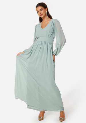A long, mint-green chiffon dress with a V-neckline, voluminous sleeves, an empire waist, and flowy skirt. Accented with a matching belt.