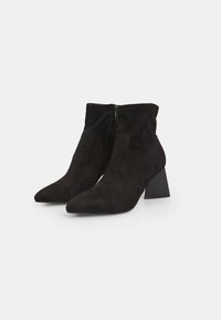 Bottines en daim noir, à bout pointu, avec fermeture éclair sur le côté et un talon épais. Finition texturée avec un design élégant.