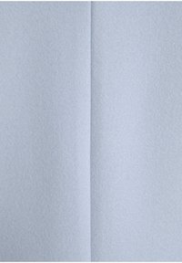 Ljusblått tyg med en slät yta, visat i två sektioner som visar en mjuk, filtliknande finish och subtil lyster.