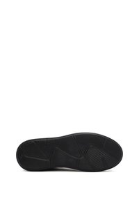 Black rubber shoe sole with textured pattern, featuring grooves and ridges for traction. Flat, oval shape with rounded edges.