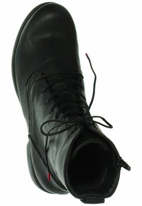 Bottine noire en cuir avec une finition texturée, bout rond, lacets à l'avant et fermeture éclair sur le côté. Présente un petit détail d'accent rouge.