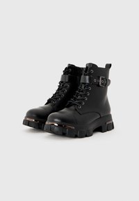 Black ankle boots with a matte finish, lace-up front, metal hardware accents, chunky soles, and a buckle strap around the ankle.