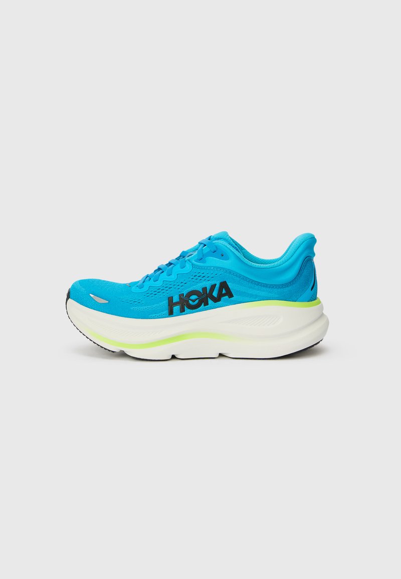 Chaussure de running Hoka bleu vif avec semelle blanche épaisse et logo noir sur le côté, montrée en profil droit sur un fond uni.