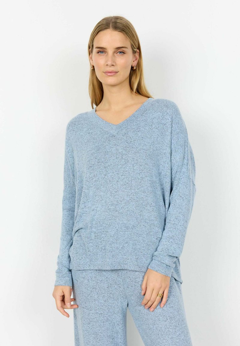 Pulover albastru deschis cu mânecă lungă și decolteu în V, confecționat dintr-un material moale și texturat. Prezintă o croială lejeră, cu tiv stratificat și umeri ușor lăsați.
