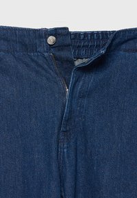 Ciemnoniebieskie dżinsy z denimu z zapięciem na guzik i suwak, wykonane z fakturowanej tkaniny, z elastycznym pasem zapewniającym wygodę.