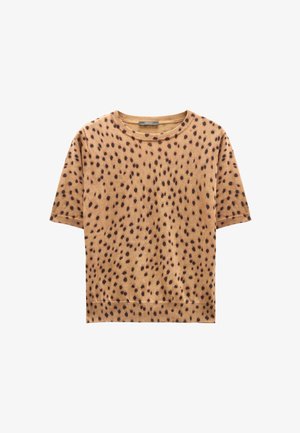 Brązowy, krótki top z dzianiny z okrągłym dekoltem i czarnym, nieregularnym wzorem w kropki.