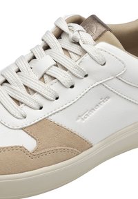 Adidași casual albi și bej cu un superior din piele și suede, vârful rotund și șireturi din material. Prezintă un logo subtil embosat pe lateral.