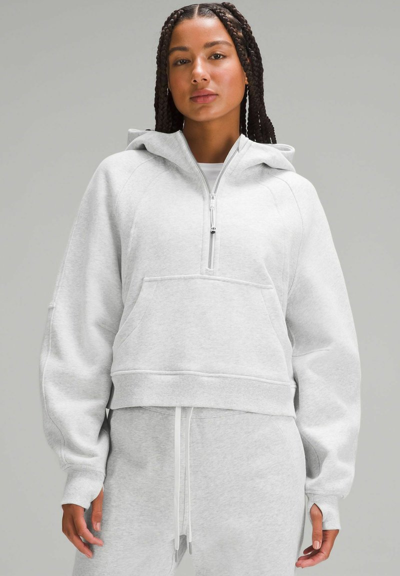 Grå kort hoodie i mjukt tyg, med dragkedja fram, ficka fram och breda mudd. Åtföljs av matchande sweatpants.