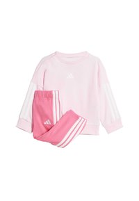 Ružový sveter a zodpovedajúce tepláky vyrobené z mäkkého materiálu. Obsahuje biele logá a pruhy Adidas na rukávoch a nohaviciach.