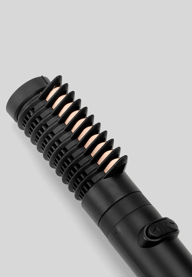 Outil de coiffure noir avec une prise texturée, featuring des accents métalliques et un bouton d'alimentation. Design cylindrique lisse avec un bouclier thermique rainuré.