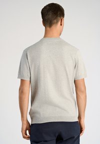 Ανοιχτό γκρι πουλόβερ με κοντά μανίκια, ριμπ λαιμόκοψη και ελαφρώς υφασμένο ύφασμα. Διαθέτει casual εφαρμογή και διακριτικές ραφές.