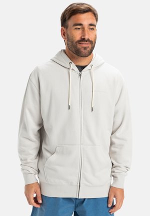 Light gray zip-up hoodie made of soft fabric, featuring a drawstring hood, front pockets, and ribbed cuffs for a snug fit.