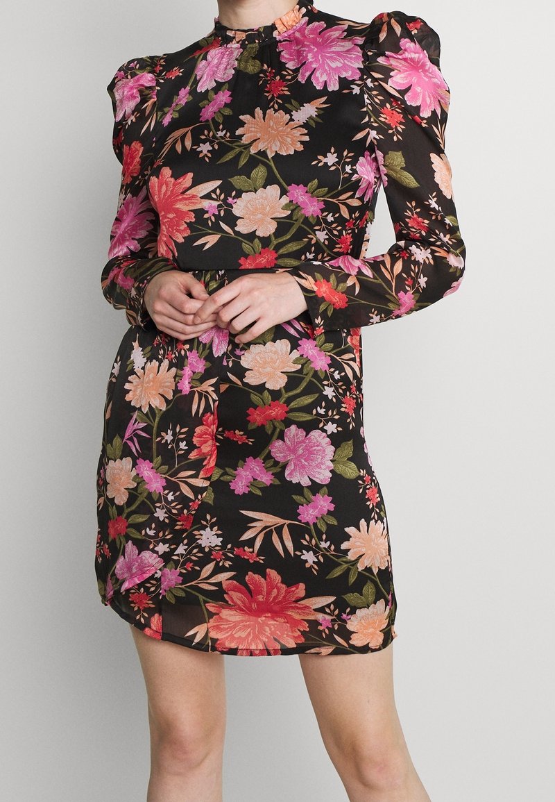 Černé květinové šaty s nafouknutými rukávy, zdobené růžovými, oranžovými a zelenými květy. Látka je lehká s vysokým výstřihem a přiléhavým střihem.