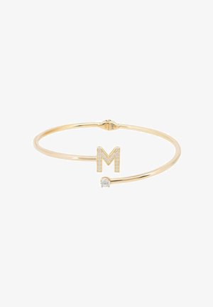 Bracelet jonc ouvert en or avec une lettre M ornée de diamants et une pierre précieuse ronde claire unique aux extrémités opposées.