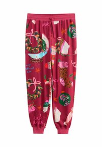 Red jogger pants with Christmas-themed prints including wreaths, stockings, ornaments, poinsettias, polar bears, and festive text.