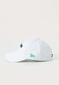 White cotton baseball cap with a curved brim, featuring colorful embroidery on the front and a logo on the side. Adjustable strap at the back.