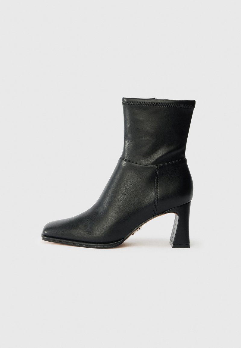 Black leather ankle boot with a pointed toe and a tapered heel. Features a fitted shaft and a zip closure at the back. Smooth texture.