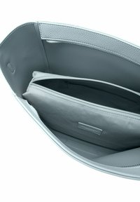 Intérieur d'un sac à main en cuir gris avec un compartiment principal, une poche zippée et un accent texturé. Doublure lisse et détails de couture subtils.