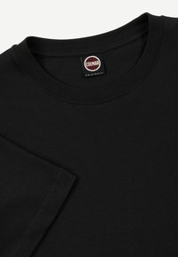 Zwarte katoenen t-shirt met ronde hals, korte mouwen en een Colmar Originals label aan de hals. Zachte, gladde tekstuur.