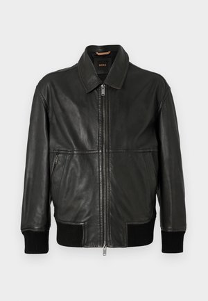 Black leather jacket with a zip front, collar, ribbed cuffs, and two side pockets. Smooth texture with minimalistic design.