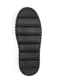 Semelle de chaussure noire en caoutchouc avec des rainures horizontales, des motifs texturés et un bout arrondi, conçue pour l'adhérence et la durabilité.
