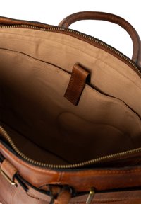 Borsa a mano in pelle marrone con interno in tessuto beige, dotata di un ampio scomparto principale aperto e di una tasca interna a soffietto con un'etichetta in pelle.