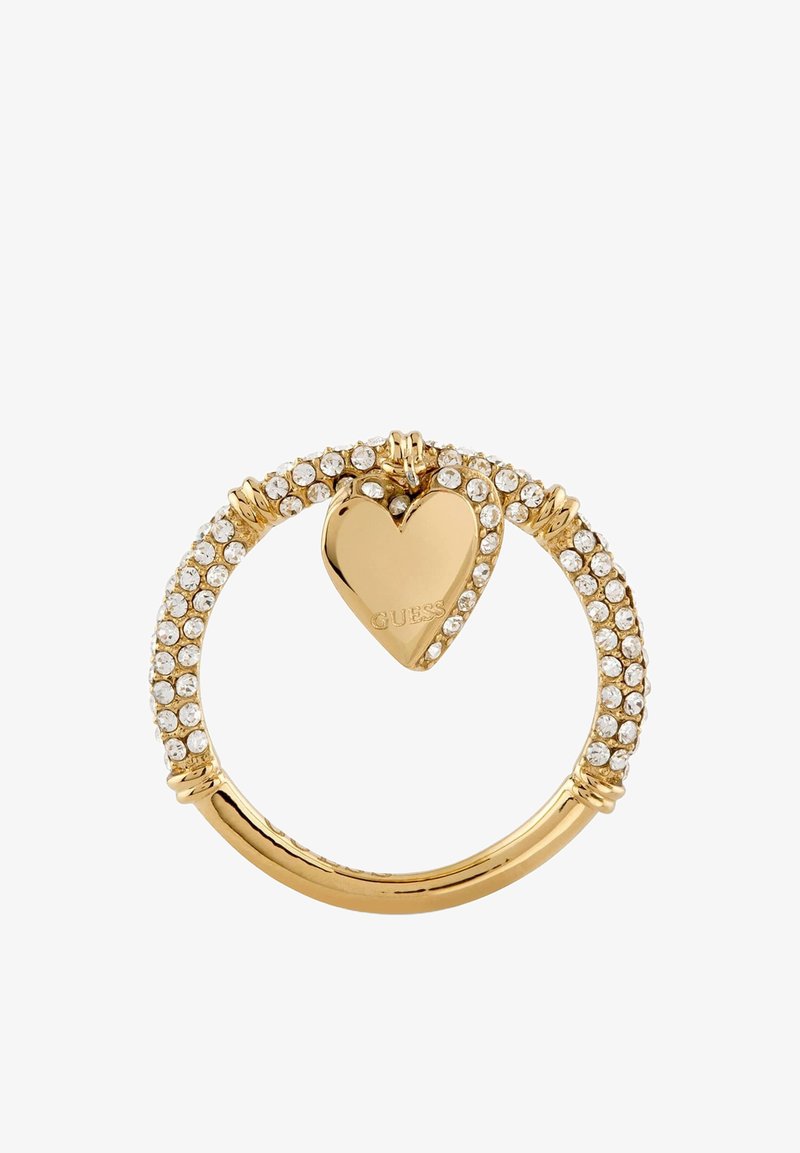 Bague en or incrustée de cristaux clairs, avec un pendentif en forme de cœur doré gravé « GUESS » et des cristaux supplémentaires sur un côté.