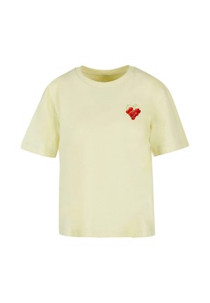 Krémové tričko s krátkým rukávem a malým potiskem červených třešní v levém horním rohu hrudi.