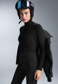 Fekete síruha illeszkedő hosszú ujjú felsővel és magas derekú nadrággal. Tartalmaz egy fekete sisakot és kabátot, amelyek letisztult dizájnt mutatnak.
